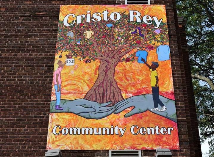 Photo shows a mural on the side of the building with an image of a tree and the name Cristo Rey Community Center.
