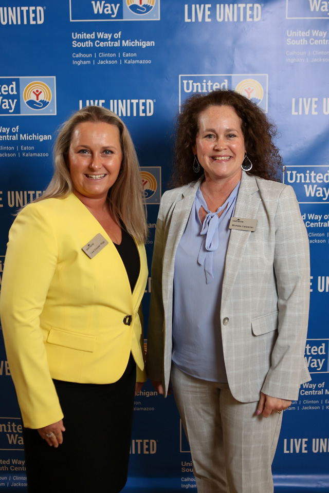 Two women pose in front of United Way backdrop