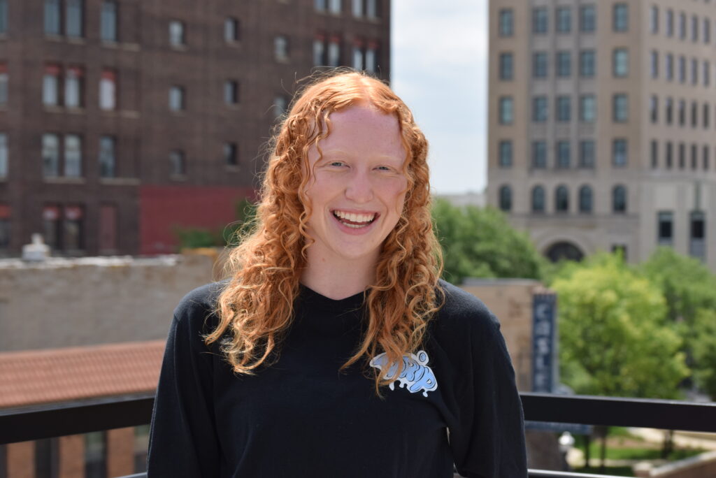 Red-haired girl smiles atop a Jackson rooftop.