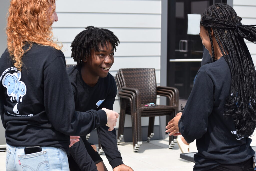 Two teens play a hand clapping game together.