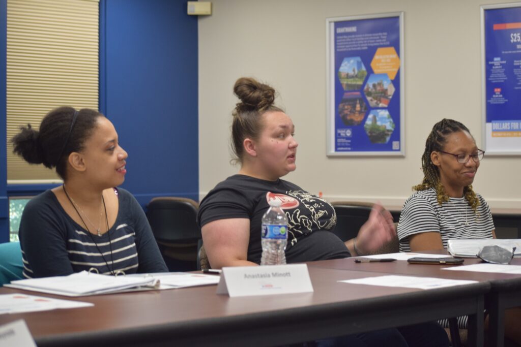 Three women sit at a table.