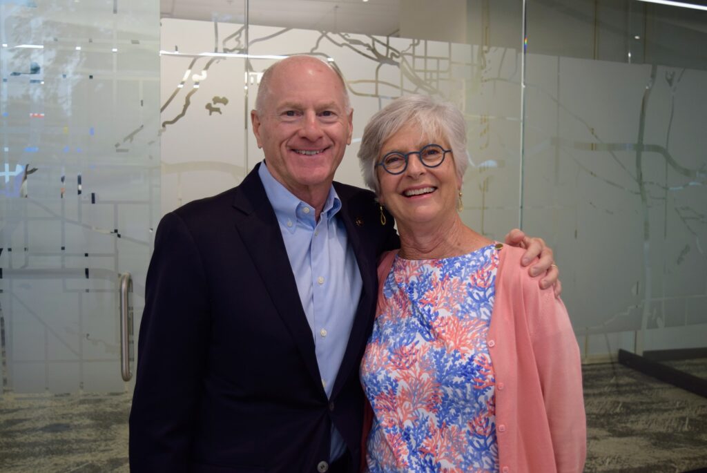 Older man with his arm around a woman.