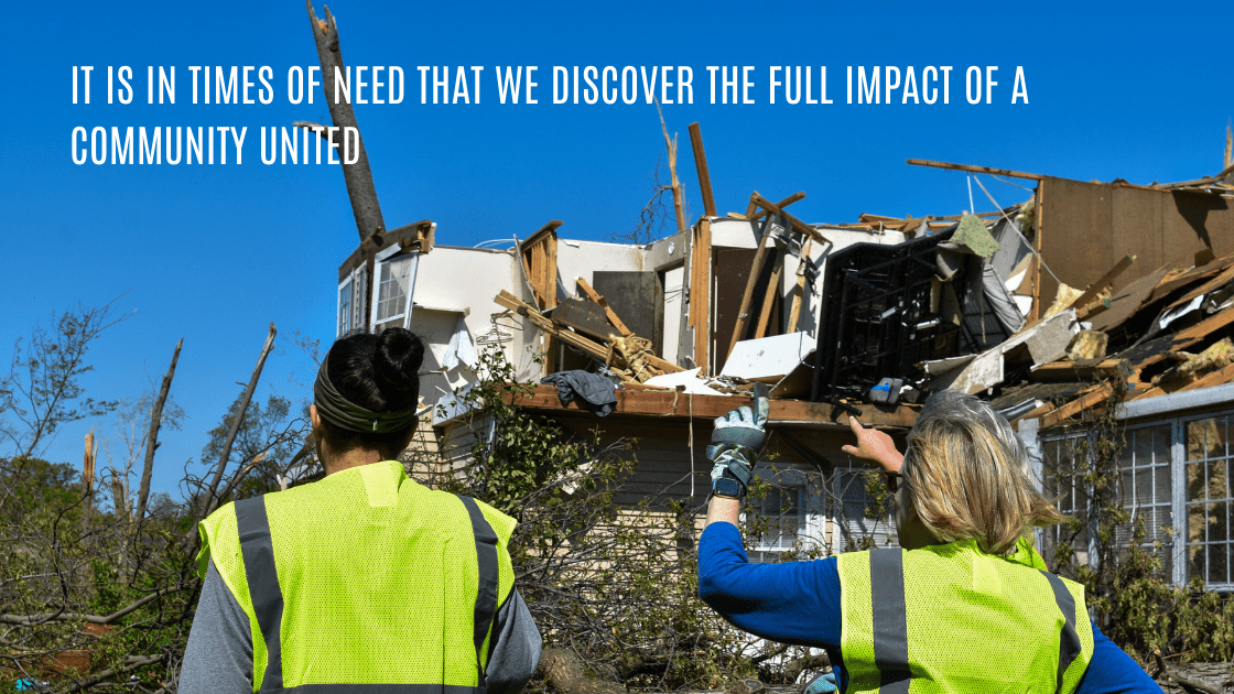 Volunteers stand in front of a damaged home. Words above read: It is in times of need that we discover the full impact of a community united.