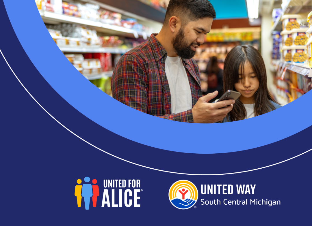 A man and a girl look at a phone inside a store.