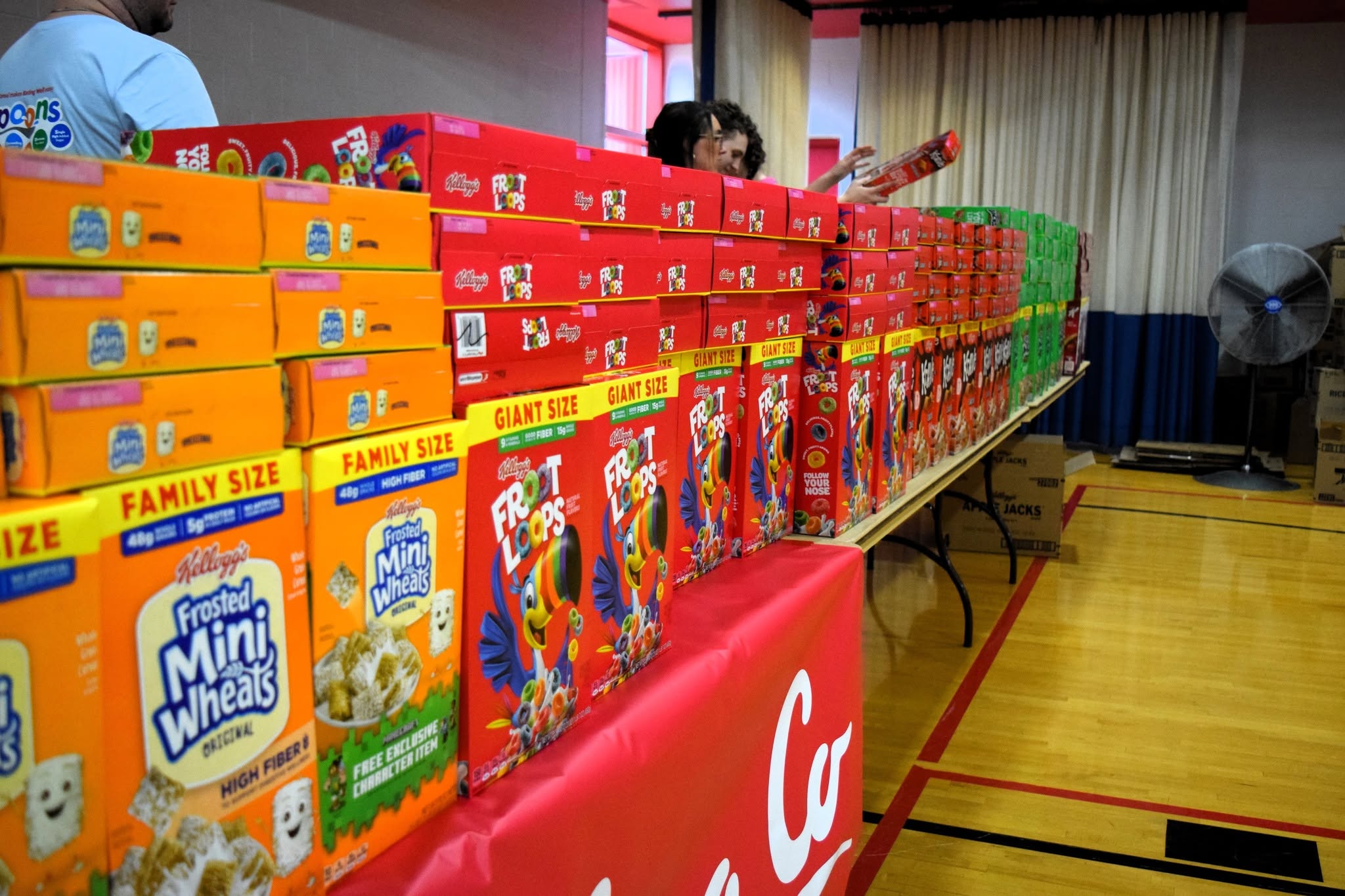 Boxes of cereal are lined up on a table.
