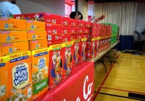 Boxes of cereal are lined up on a table.