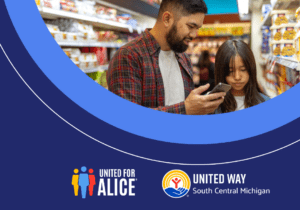 A man and a girl look at a phone inside a store.